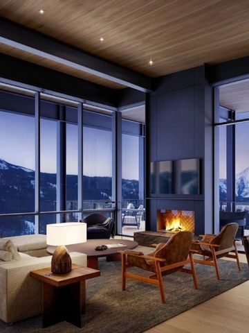 Wohnzimmer mit Kamin und Panoramablick auf schneebedeckte Berge bei Abenddämmerung