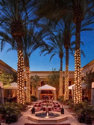 Abendliche Oase mit beleuchteten Palmen und gemütlichen Sitzbereichen