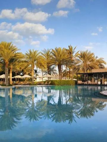 Weitläufiger Poolbereich mit Palmen und gemütlichen Liegen im One&Only Royal Mirage