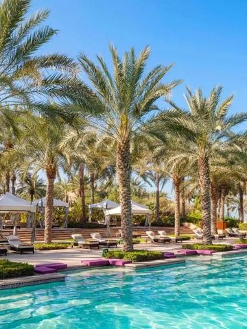 Eleganter Poolbereich mit Palmen und weißen Cabanas im Hotel One&Only Royal Mirage