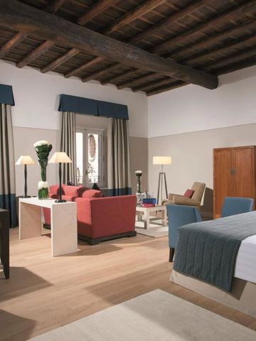 Helles und geräumiges Hotelzimmer mit Holzbalkendecke und modernen Möbeln