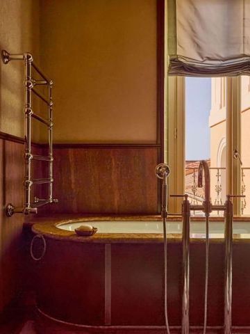 Badezimmer mit Badewanne und Blick auf Außenbereich durch Fenster