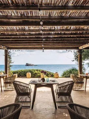 Überdachte Terrasse mit Meerblick und stilvollen Sitzgelegenheiten