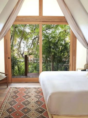 Zimmer mit großen Fenstern und grüner Aussicht