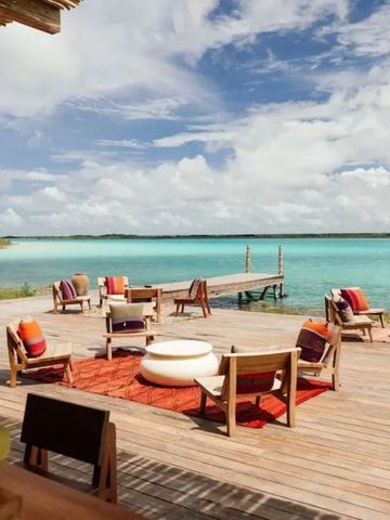 Holzterrasse mit gemütlichen Sitzbereichen am türkisblauen Wasser