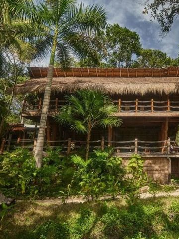 Rustikale Villa mit Strohdach inmitten üppiger Vegetation