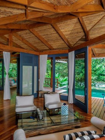 Luxuriöser Wohnbereich aus Holz mit Poolblick und tropischer Umgebung