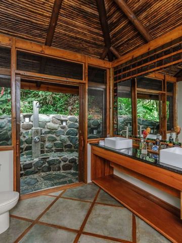 Luxuriöses Badezimmer mit Outdoor-Dusche und Blick ins Grüne