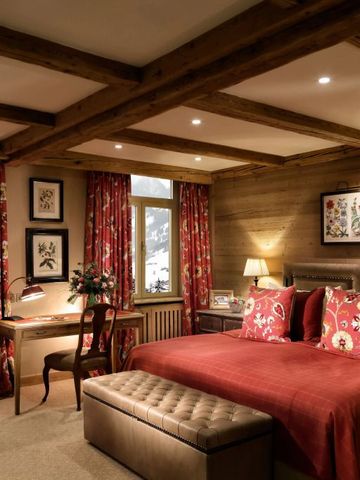 Elegantes Schlafzimmer dekoriert mit roten Akzenten und Bergblick