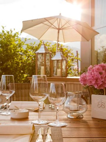 Elegant gedeckter Tisch auf sonniger Terrasse mit Blick auf die Berge