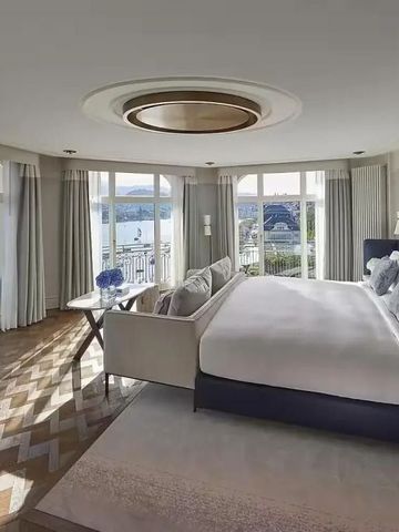 Helles Hotelzimmer mit Panorama-Fenstern und Seeblick