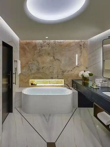 Modernes Badezimmer mit freistehender Badewanne und Marmorwänden