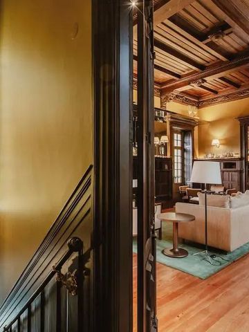 Historisch gestaltetes Wohnzimmer mit buntem Glasfenster und eleganter Einrichtung.