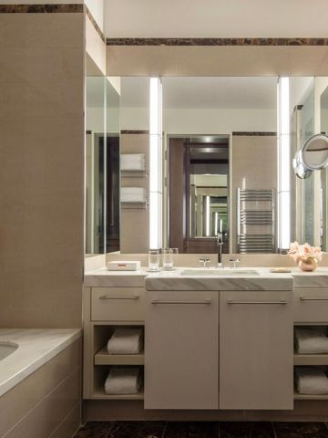 Modernes Badezimmer mit großem Spiegel und eleganter Beleuchtung.