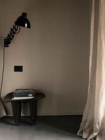 Minimalistisch eingerichtetes Zimmer mit Tischlampe und Bett