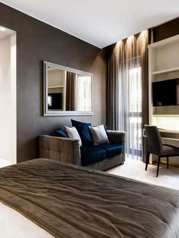 Zimmer mit gemütlichem Bett, eleganter Sitzgelegenheit und Schreibtisch