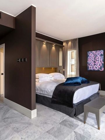 Modern eingerichtetes Hotelzimmer mit Kunst an der Wand und weichen Kissen.