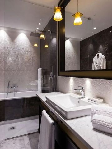 Luxuriöses Badezimmer mit Marmorwaschtisch und Dusche neben Badewanne