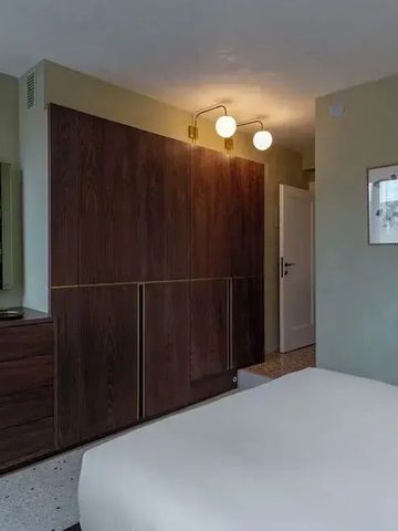 Gehobenes Schlafzimmer mit Holzschrank und dekorativer Beleuchtung