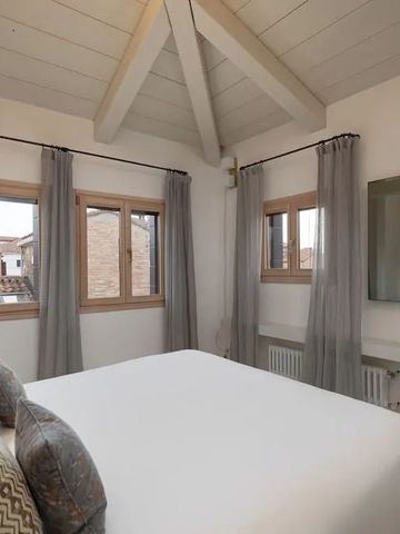 Helles Schlafzimmer mit Dachbalken und klassischem Fensterblick