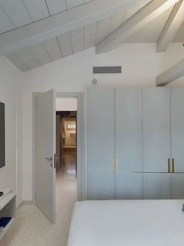 Elegantes Hotelzimmer mit sichtbaren Holzbalken und großem Kleiderschrank