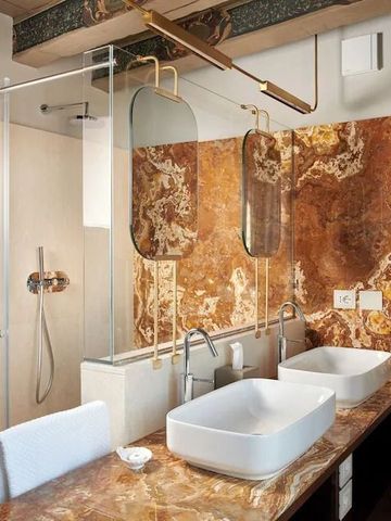 Badezimmer mit Doppelwaschbecken und aufwändigen Marmordetails