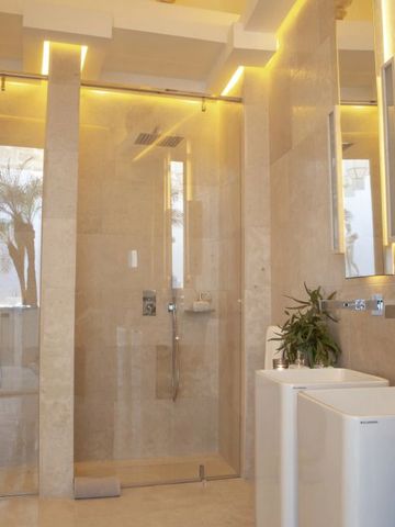 Modernes Badezimmer mit Glasdusche und dezenter Beleuchtung