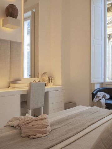 Elegantes Hotelzimmer mit heller Einrichtung und großem Fenster.