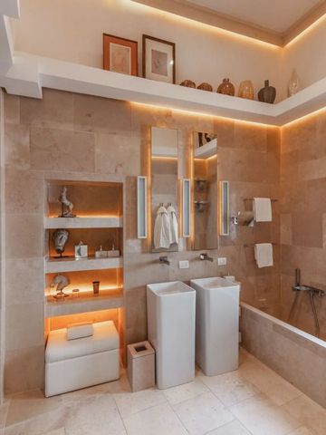 Geräumiges Badezimmer mit Doppelwaschbecken und dekorativer Beleuchtung.