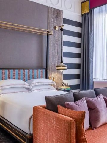 Elegantes Hotelzimmer mit komfortablem Bett und stilvollem Sofa.