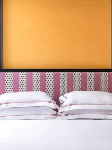 Nahaufnahme eines luxuriösen Bettes mit dekorativem Kopfteil.