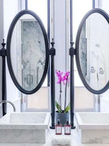 Modernes Badezimmer mit eleganten Spiegeln und Orchidee.