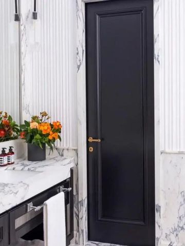 Marmorbadezimmer mit eleganter Einrichtung und Blumenarrangement.