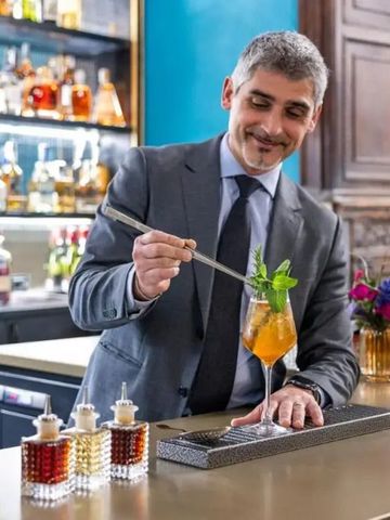 Barkeeper im Anzug mixt einen Cocktail an einer stilvollen Hotelbar