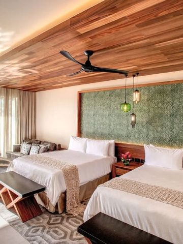 Zwei Betten in einem luxuriösen Zimmer mit modernem Dekor und Meerblick