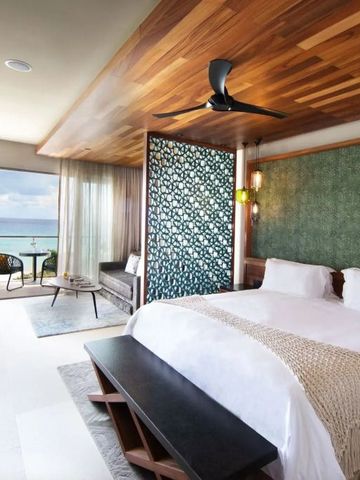 Luxuriöses Schlafzimmer mit Kingsize-Bett und Meerblick auf Balkon