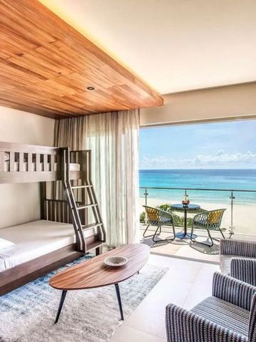 Zimmer mit Stockbett und Balkonterrasse mit Blick auf das Meer