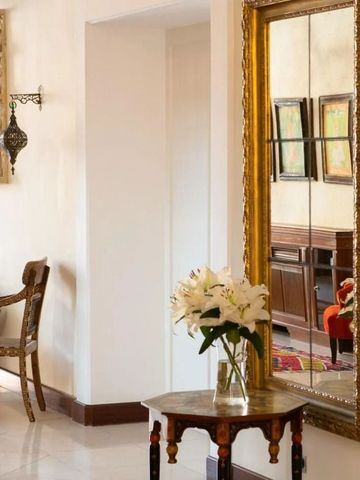 Stilvoller Flurbereich mit großem Spiegel und kunstvollen Möbeln