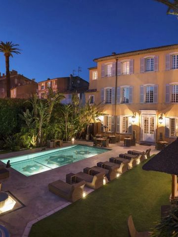 Außenansicht des Hotels bei Abenddämmerung mit beleuchtetem Pool