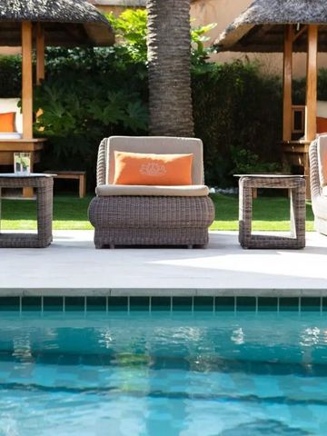 Entspannungsbereich am Pool mit bequemen Liegen und Palmen