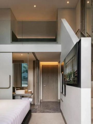 Modernes Hotelzimmer mit Treppe und großem Fernseher