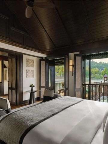 Modernes Zimmer mit Balkon und Seeblick in tropischer Umgebung