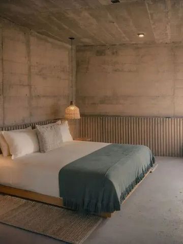 Modernes Schlafzimmer mit Betonwänden und elegantem Doppelbett