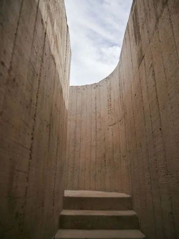 Architektonisches Detail mit hohen Betonmauern und Himmelsblick