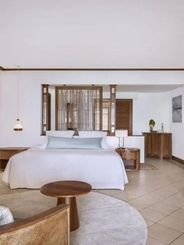 Geräumiges Hotelzimmer mit großem Doppelbett und moderner Einrichtung