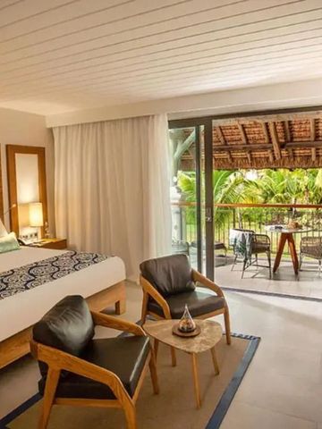 Modernes Hotelzimmer mit Balkon und Blick auf tropische Vegetation