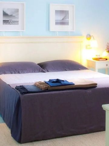 Helles Zimmer mit Doppelbett und blauen Akzenten