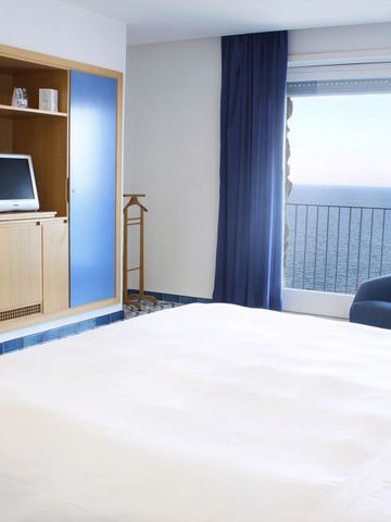 Hotelzimmer mit Meerblick und blauem Vorhang