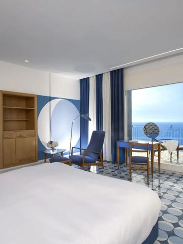 Geräumiges Hotelzimmer mit großen Fenstern und Meerblick