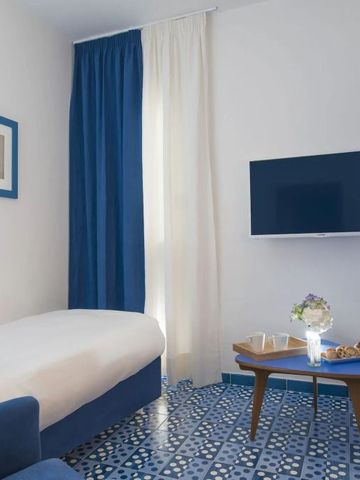 Helles Hotelzimmer mit blauem Dekor und modernem Kunstwerk an der Wand